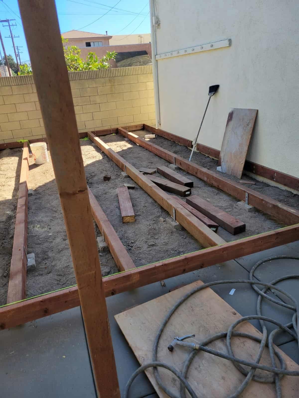 New wooden deck framework under construction for a backyard remodeling project.