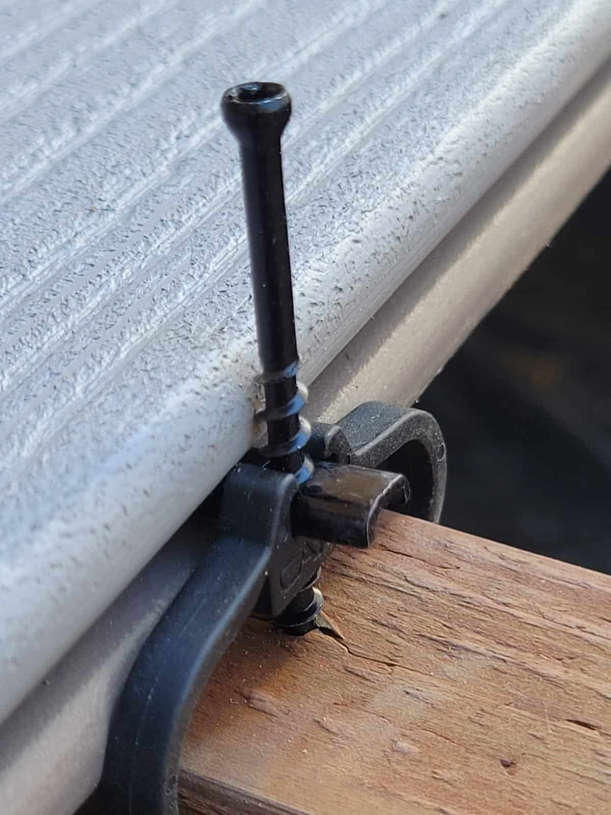 Bolt securing siding to wall for maintenance or repair.